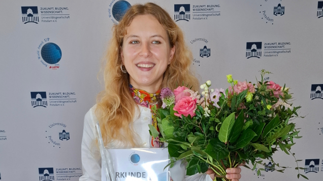Foto von Valeriya Denisova mit Blumen, Urkunde und Better World Award 2025