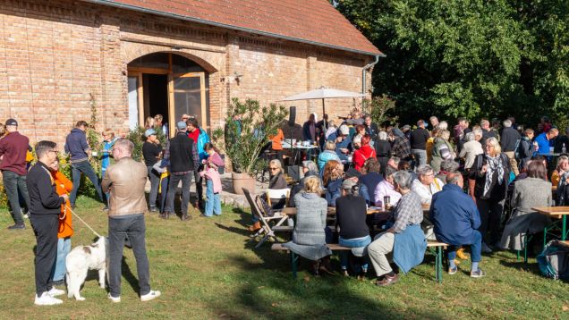 Foto vom Demokratiefest Rutenberg mit vielen Personen auf einer Dorfwiese an Tischen und Bänken