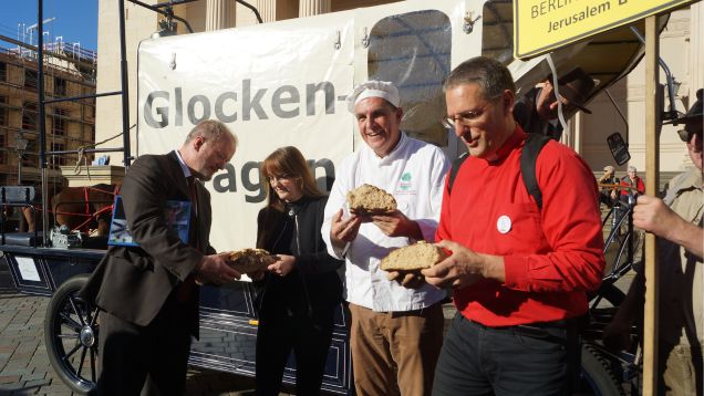 Brot brechen mit Ministerin Katrin Lange am Glockenwagen für den Friedenstreck
