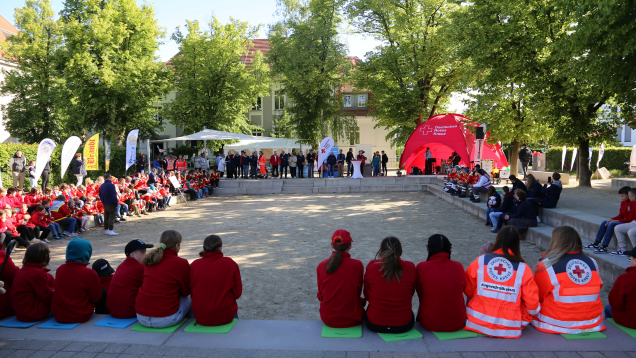 Foto Teilnehmern des Wettbewerbs auf einem Platz unter grünen Bäumen versammelt
