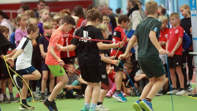 Sportgruppe mit Trainerin in Sporthalle durch Kooperation Verein-Schule
