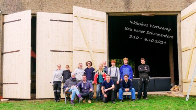 Helfergruppe vor den neuen Scheunentoren des Distelhof