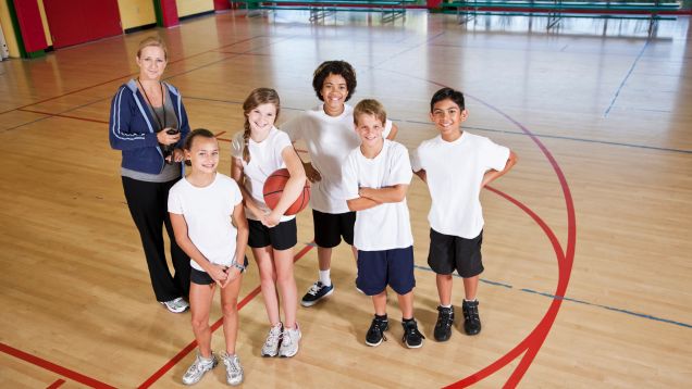 Sportgruppe mit Trainerin in Sporthalle durch Kooperation Verein-Schule