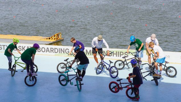 Foto einer Gruppe jugendlicher Freestyler mit BMX-Rädern in einer Skatearea