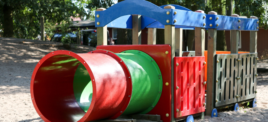 Bahnhof Tantow wird umgestaltet Eine bunte Holzeisenbahn steht auf einem Spielplatz im Sand.