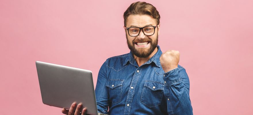 Symbolbild: Brandenburger gewinnt mit KENO Mann mit Laptop in rechter Hand freut sich