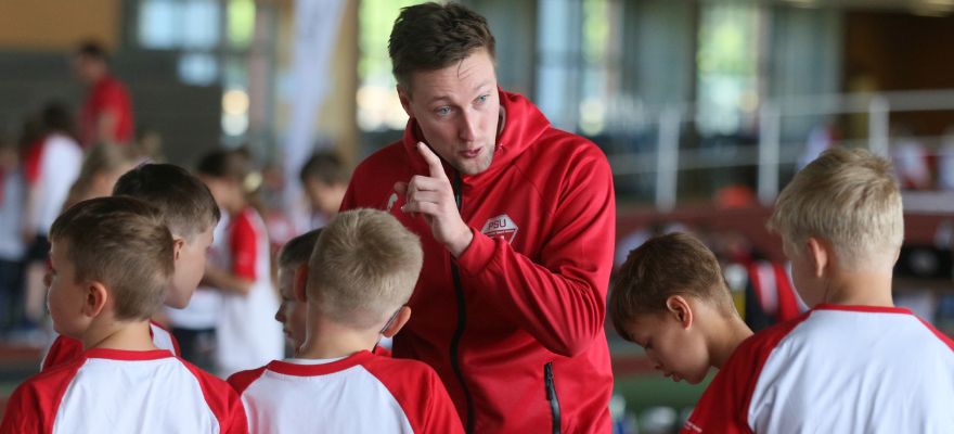 Brandenburgs Sportsympathiegewinner:innen 2024 gesucht Mann mit roter Sportjacke erklärt Kindern die Regeln